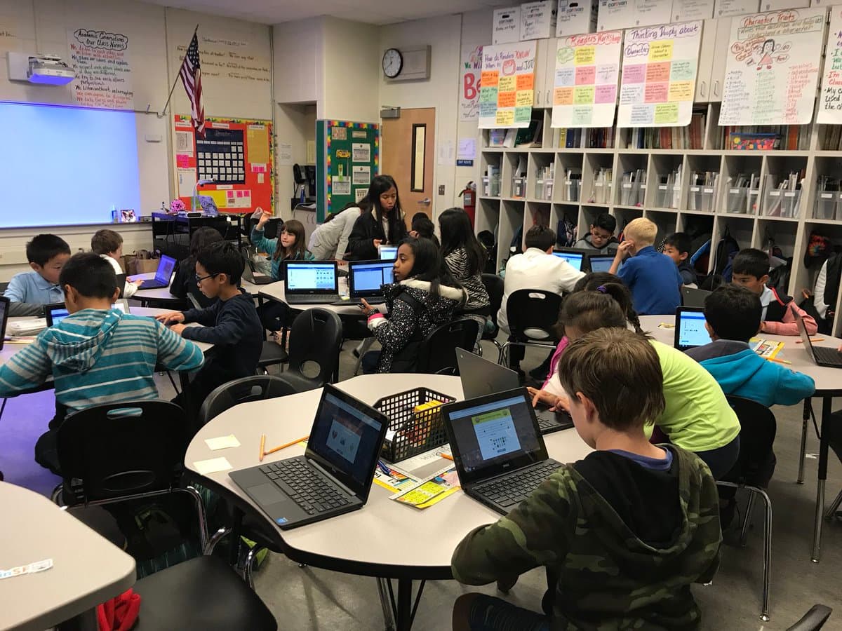 A full classroom of students coding together