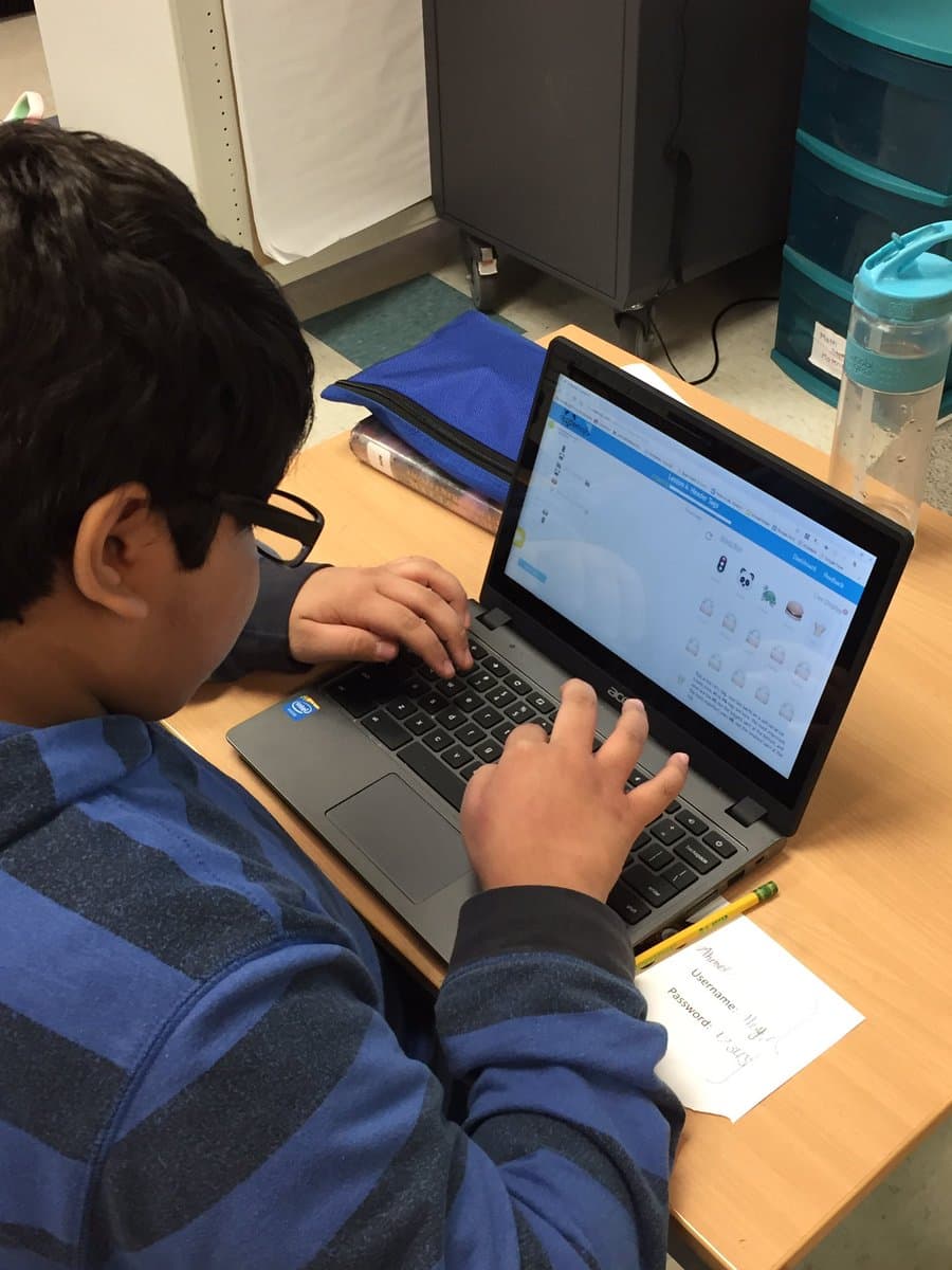 A student typing code on a Chromebook